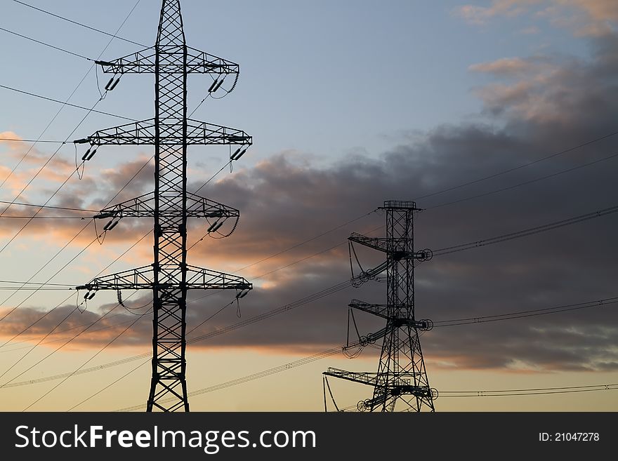 High voltage power pylons on against sunset sky. High voltage power pylons on against sunset sky