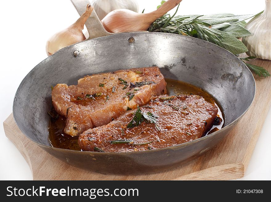 Pork tenderloin marinated with spices in a pan