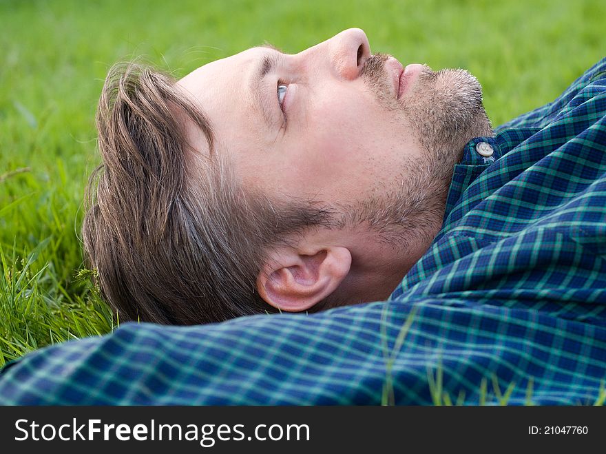 Portrait of a cute man lying on a grass. Portrait of a cute man lying on a grass
