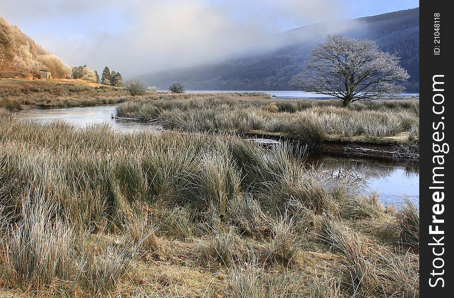 A frosty morning with ice on the water and mist in the valley at Talybont Reservoir, Wales, UK. A frosty morning with ice on the water and mist in the valley at Talybont Reservoir, Wales, UK