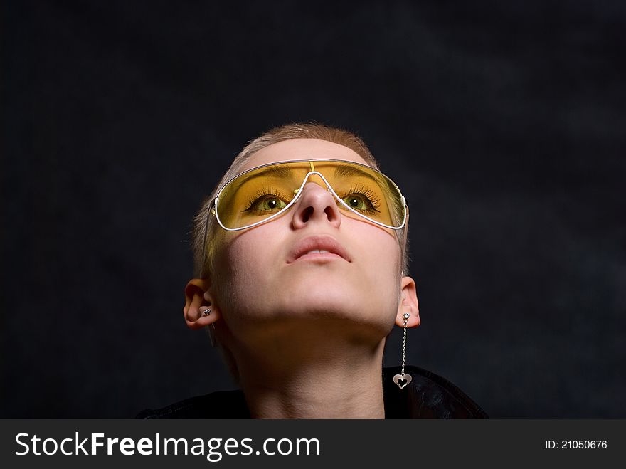 The young girl in a leather jacket and yellow glasses