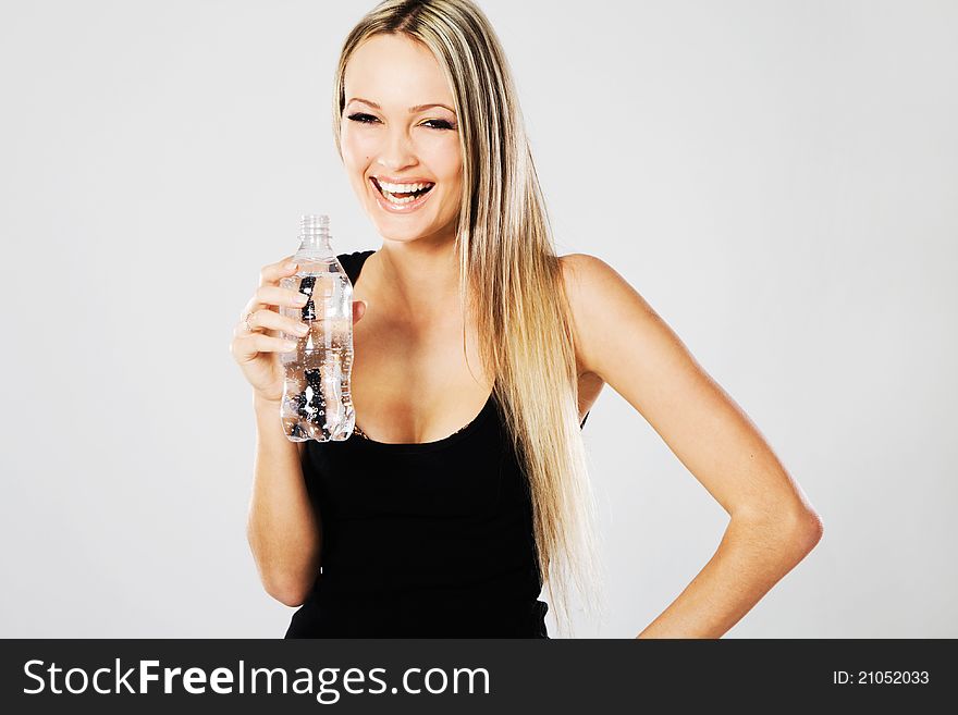 Cheerful beautiful woman with a bottle of fresh water. Cheerful beautiful woman with a bottle of fresh water