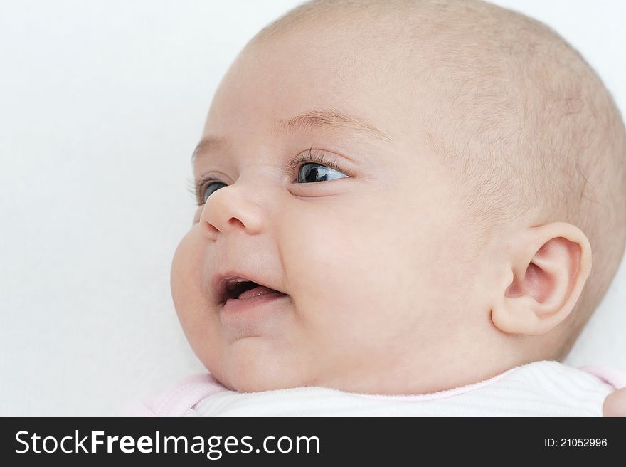 Profile of smiling newborn with blu eyes on white background. Profile of smiling newborn with blu eyes on white background