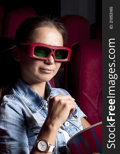 Young woman sitting alone in the cinema and watching a movie. Young woman sitting alone in the cinema and watching a movie