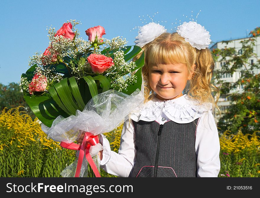 Schoolgirl with nice flowers outdoors goes to school