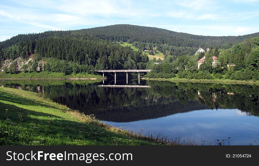 Bridge across the crystal-clear river. Bridge across the crystal-clear river