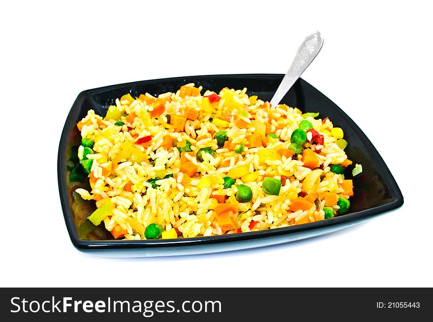 Black square plate with salad from rice and vegetables. Isolated on a white background