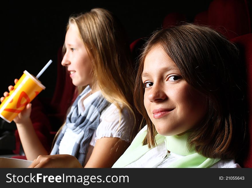 Two young girls watching movie in cinema. Two young girls watching movie in cinema