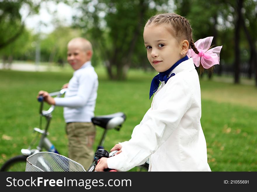 Happy smiling girl on a bicycle in the green park