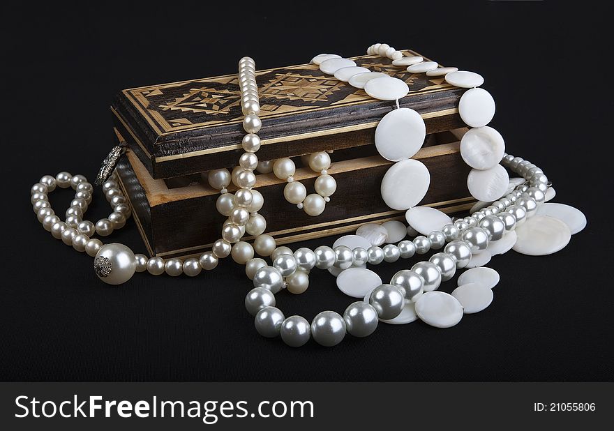 Casket with pearls on black background