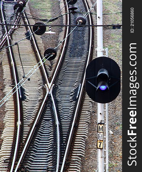 Railroad tracks with a semaphore blue light at morning. Railroad tracks with a semaphore blue light at morning