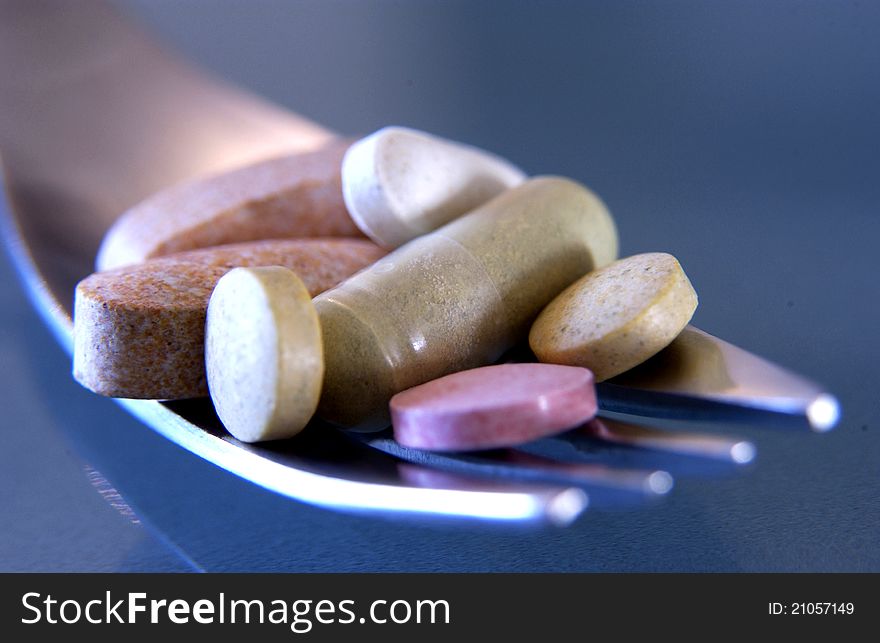 Close up of various pills on fork