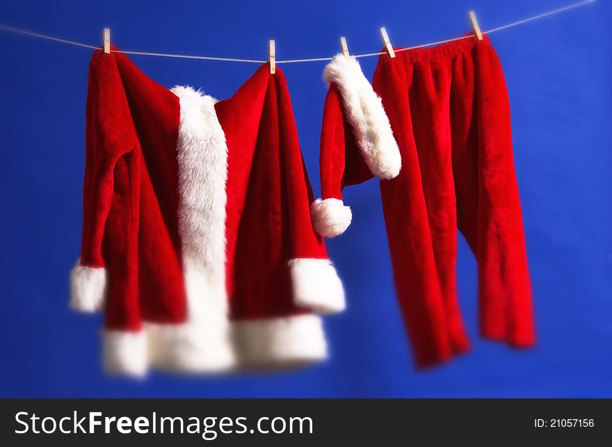 Santa's outfit hanging on line with blue background. Santa's outfit hanging on line with blue background