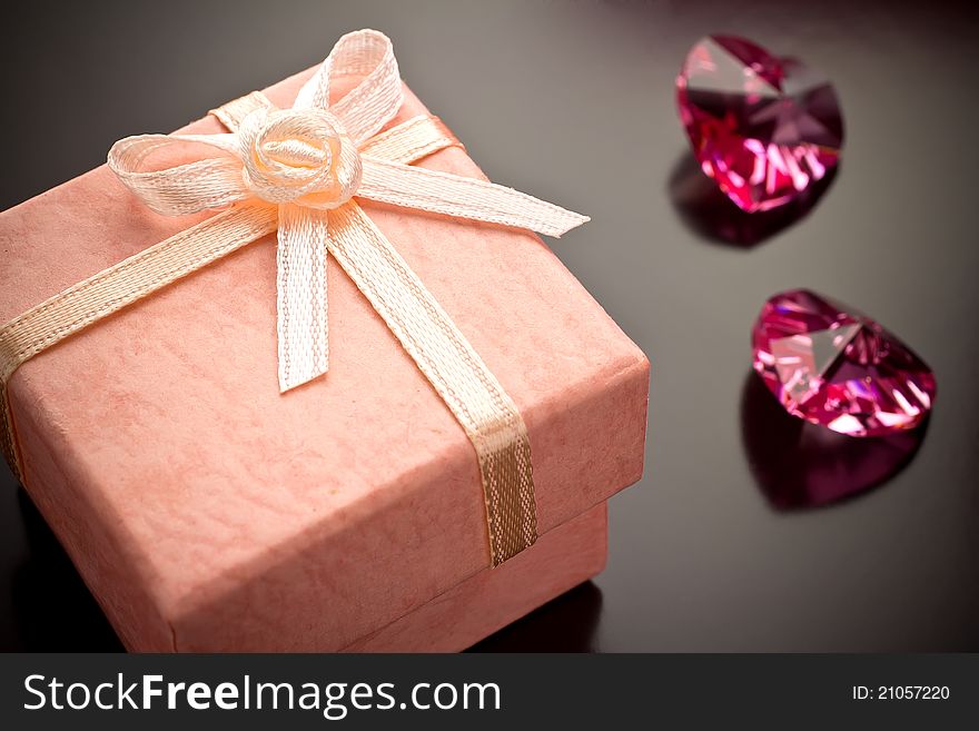 Pink gift box, pink crystals on a gray background. Pink gift box, pink crystals on a gray background.