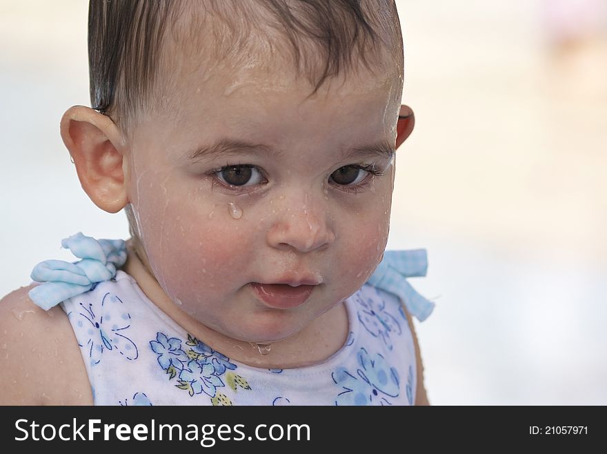 Wet little girl with a serious expression isolated on bright background. Wet little girl with a serious expression isolated on bright background