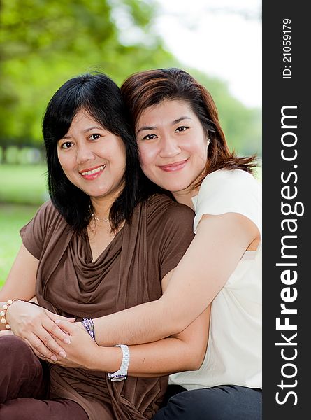 Portrait of two asian women hugging each other