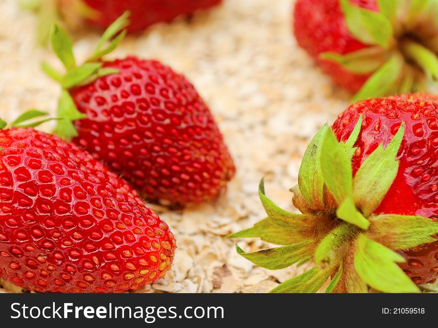 Red strawberries on oat grains background