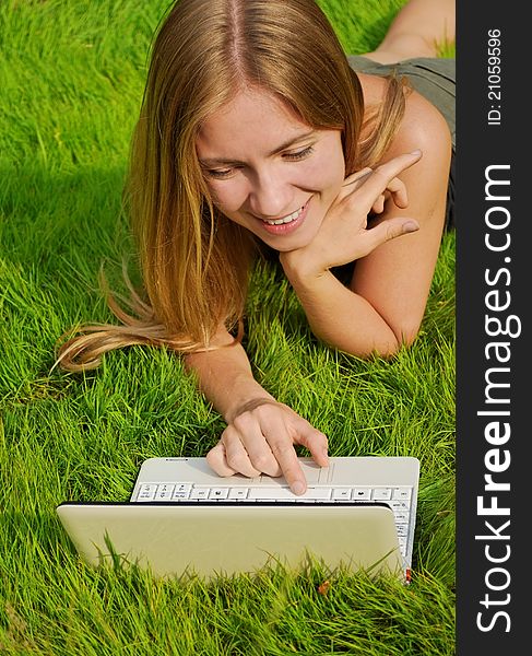 Girl on lawn working on laptop