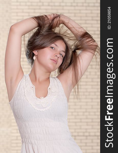 Portrait of the girl against a brick wall