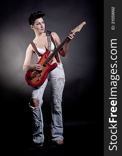 Sexy girl with a guitar playing rock