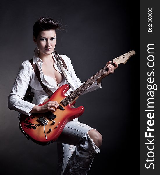 Sexy girl with a guitar playing rock