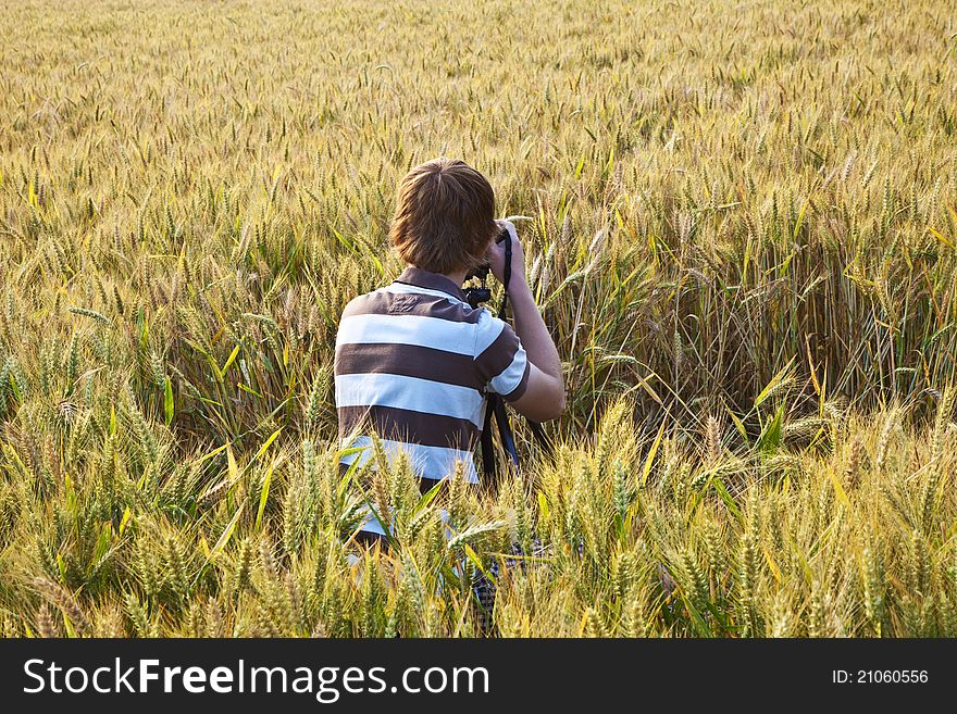 Fotographer in corn field with camera