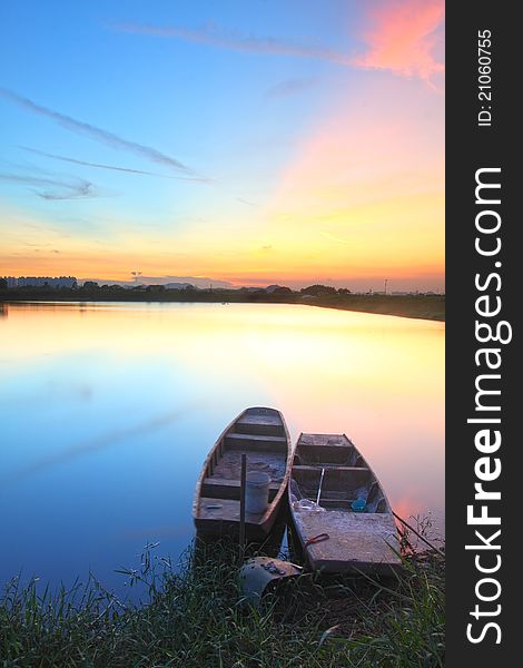 Sunset with isolated boats in water body