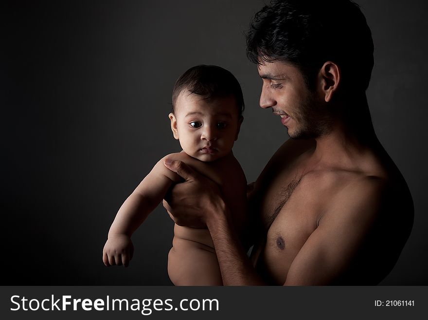 Indian father and son in happy pose over black background. Indian father and son in happy pose over black background
