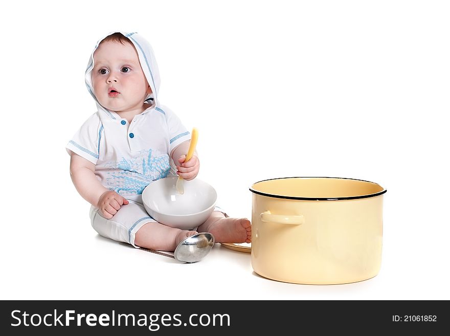 Funny little boy wearing white overalls with a hood playing with the dishes studio portrait (isolated on white background). Funny little boy wearing white overalls with a hood playing with the dishes studio portrait (isolated on white background)