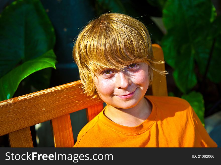 Boy relaxing on a bench in the botanical garden