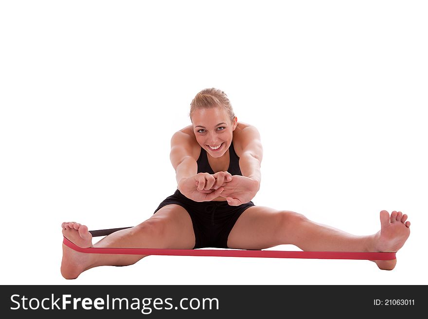 A young beautiful woman is doing exercises with a red stretch band. A young beautiful woman is doing exercises with a red stretch band