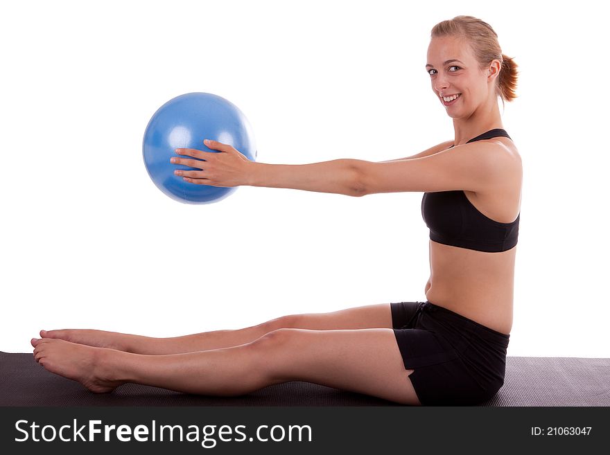 A young woman is doing exercises with a blue ball. A young woman is doing exercises with a blue ball