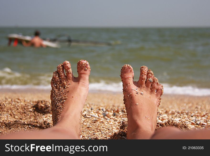 Feet on the shore during the summer of windsurfing