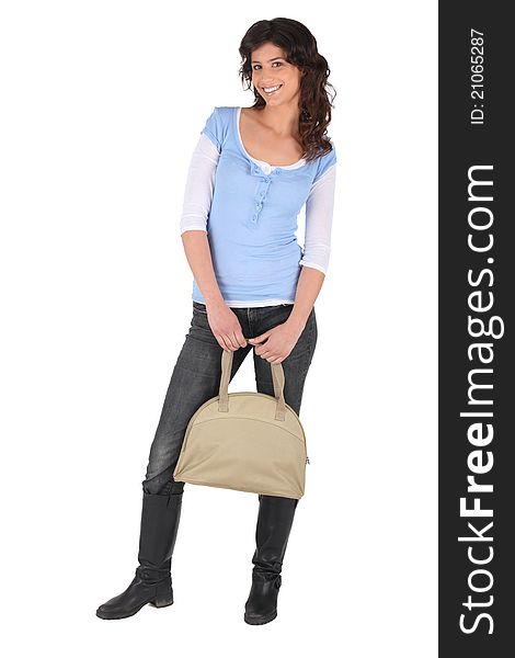 Studio full length shot of a young woman with a beige handbag