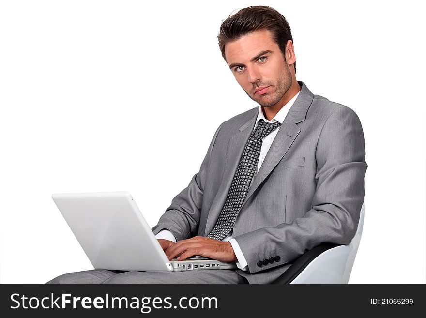 Businessman sat in chair typing on laptop. Businessman sat in chair typing on laptop