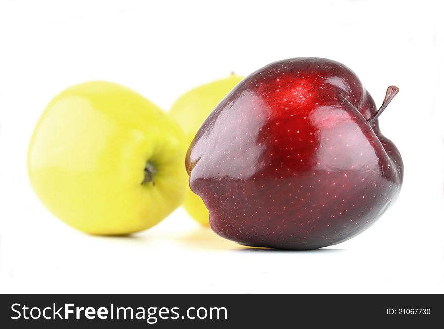 Three different color apples, focus on red one