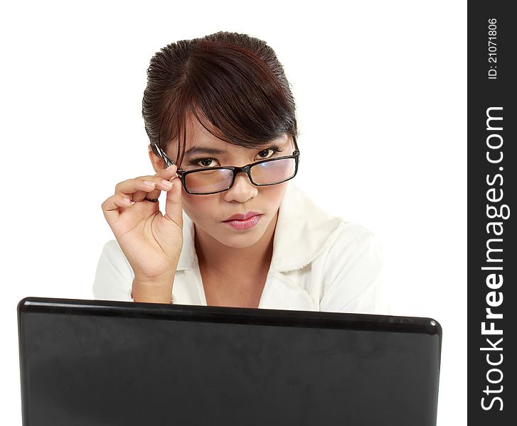 Serious beautiful young woman working with her laptop in front of her