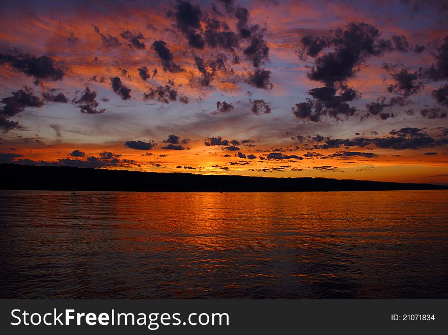 Sunset on Cayuga Lake in Ithaca, NY. Layered clouds with different colors. Sunset on Cayuga Lake in Ithaca, NY. Layered clouds with different colors.