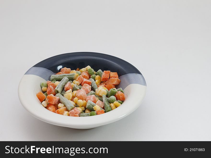 A Bowl of frozen mixed vegetables...in white background