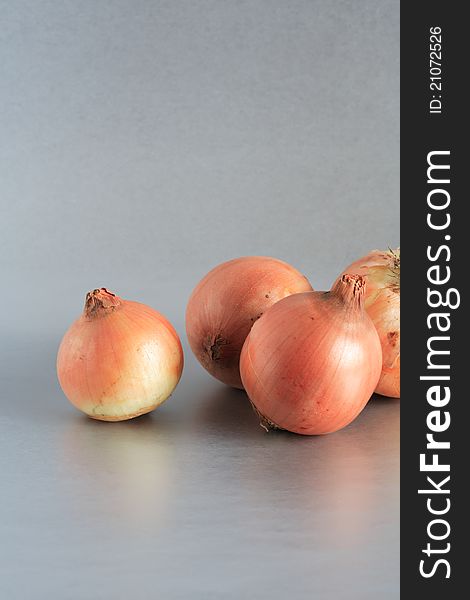 Closeup of few onions on beautiful gray background. Closeup of few onions on beautiful gray background