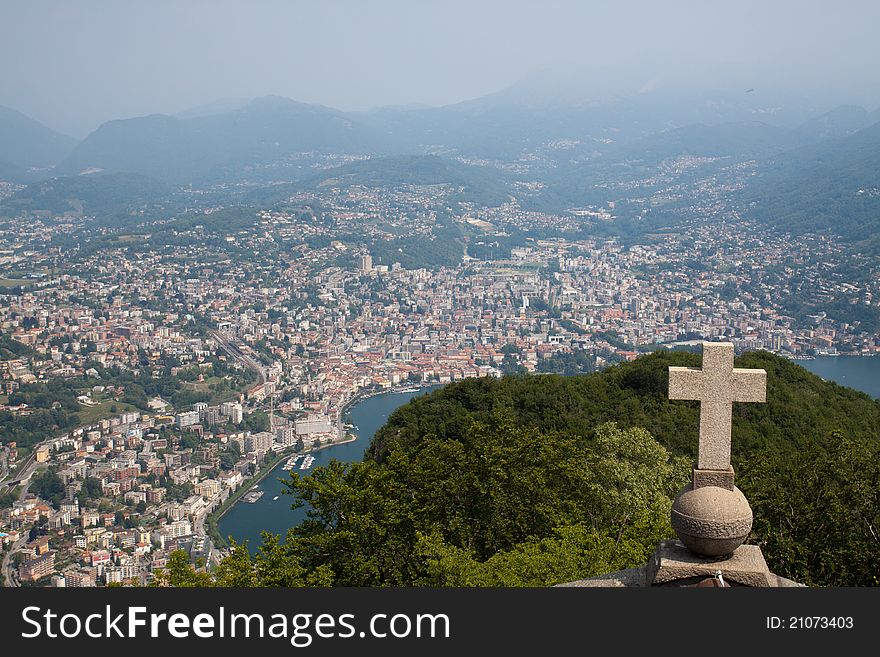 View of Lugano from San Salvatore mountain with a cross in front. View of Lugano from San Salvatore mountain with a cross in front