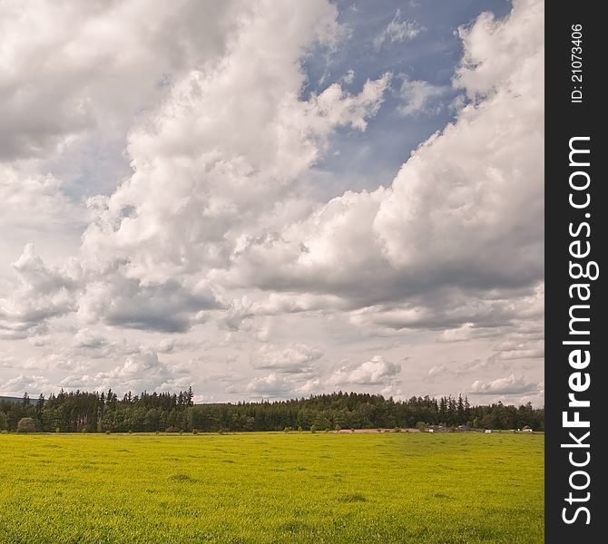 Retro colors shot - Green meadow and sky with many clouds