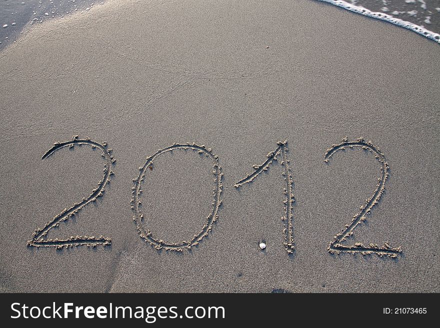 New year 2012 on the beach written on the sand