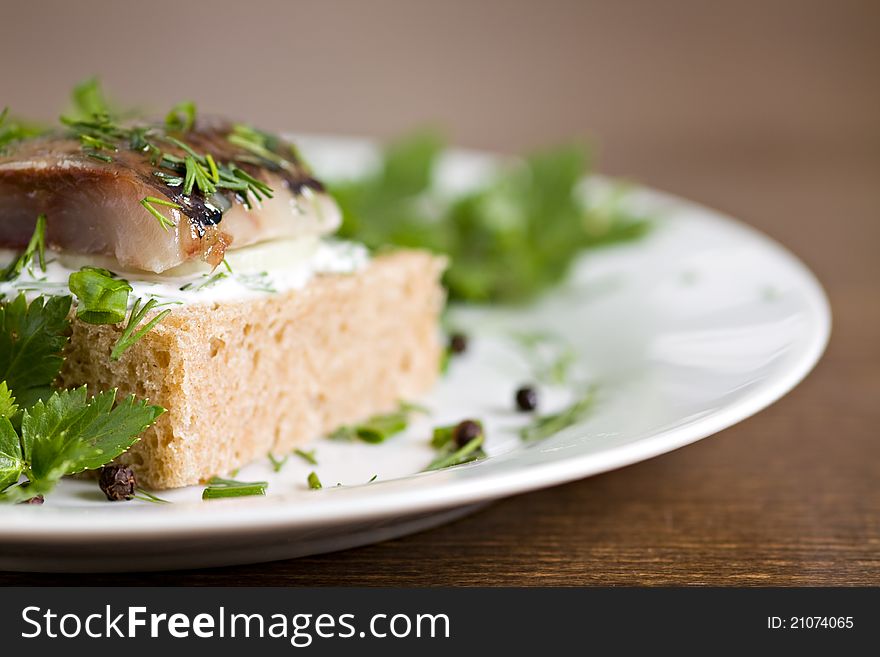 Sandwich with herring and white sauce on white plate