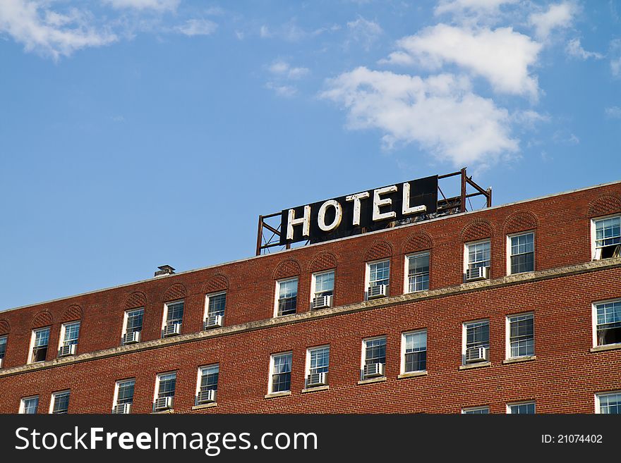 Hotel sign on an old brick building against a blue sky