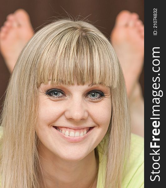 Close up of the person of the smiling girl with feet against a dark background. Close up of the person of the smiling girl with feet against a dark background