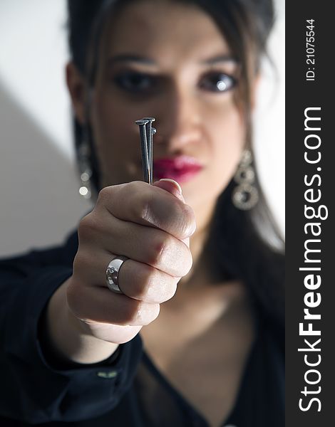 Woman holding nails in her fist...with a diamond ring on her hand