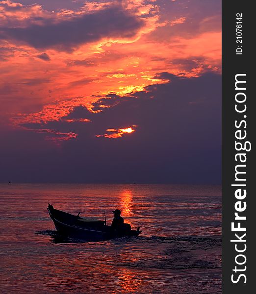 Fishermen in boat at sunrise