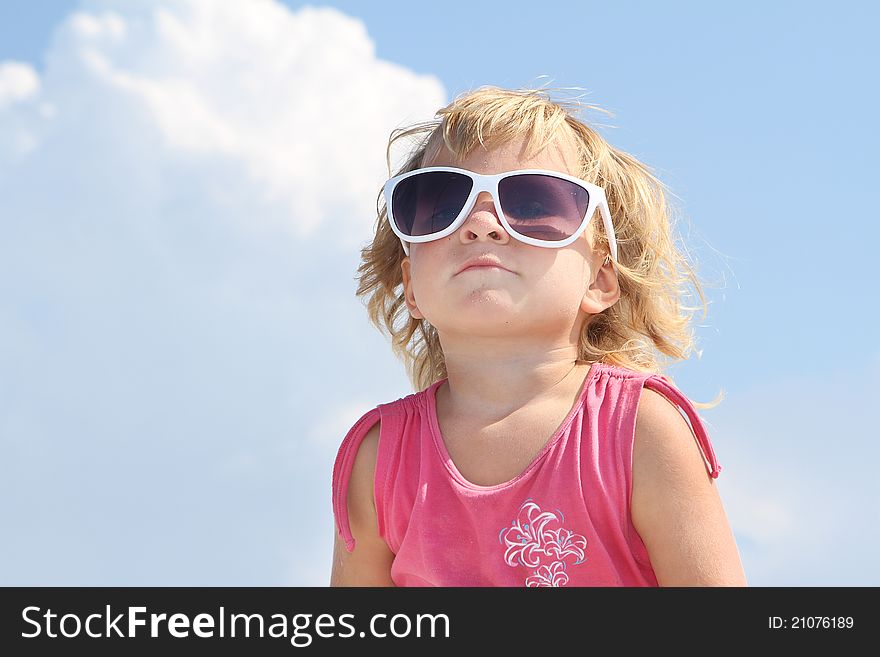 Cute young girl in sun glasses over sky background