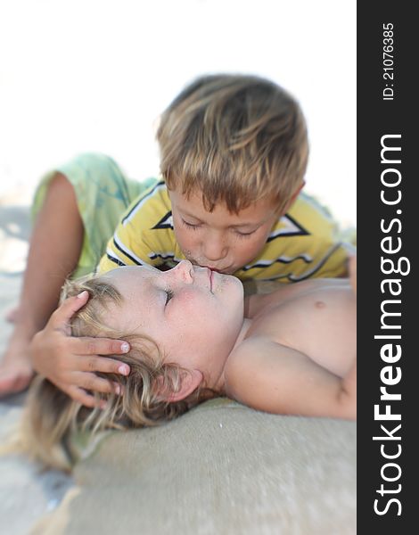 Brother kissing his younger sister, partly isolated over white. Brother kissing his younger sister, partly isolated over white